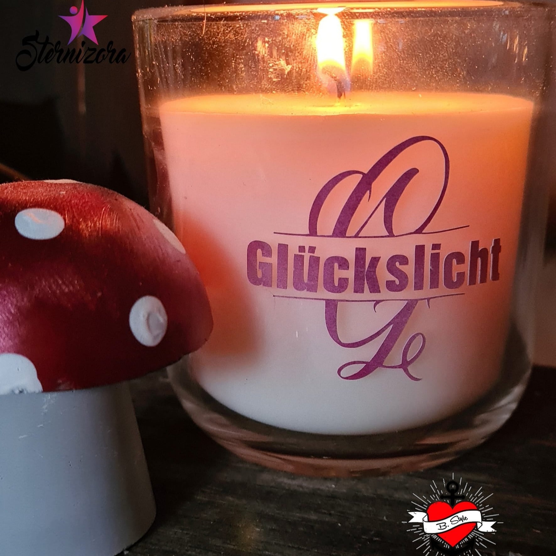 Monogramm 'G' Plotterdatei von easy-sticks, dekorative Kerze mit dem Schriftzug GLÜCKSLICHT in lila mit stilisierten Buchstaben auf einem rustikalen Hintergrund.