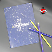 Notizbuch mit dem Titel INSPIRATION und dem Monogramm "I", gestaltet von easy-sticks, umgeben von bunten Buntstiften auf einer grauen Oberfläche.