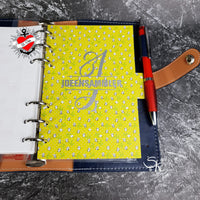 Planer-Seite mit dem Monogramm "I" und dem Wort IDEENSAMMLER, entworfen von easy-sticks, in strahlendem Gelb mit einem verspielten Blumenmuster.