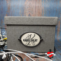 Stylische Aufbewahrungslösung mit der Monogramm "K" Plotterdatei von easy-sticks. Die graue Box, beschriftet mit "KABELSALAT", zeigt die kreative Anwendung dieser digitalen Datei für DIY-Projekte und individuelles Design.