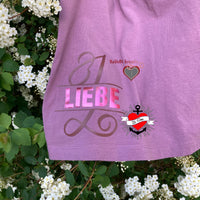 Kreatives T-Shirt mit dem Monogramm "L" aus der Plotterdatei von easy-sticks, das Wort "LIEBE" in verspieltem Design, umgeben von Blüten. Perfekt für individuelle Bastelprojekte.