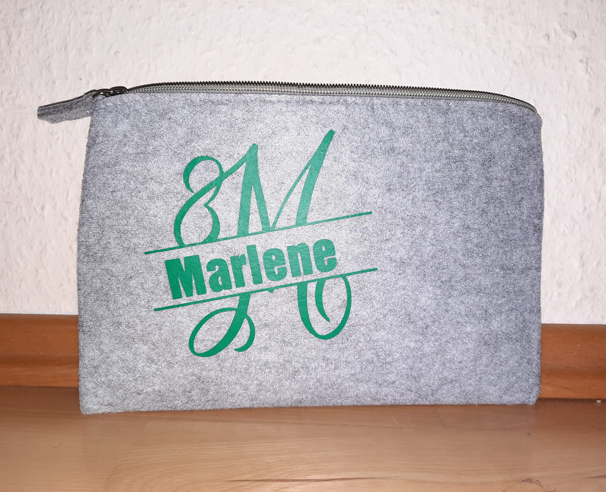 Monogramm "M" Plotterdatei auf einer grauen Filztasche mit dem Namen "Marlene" und dem Logo von easy-sticks. Stilvolle Aufbewahrung für kreative Köpfe.