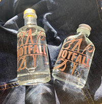 Zwei klare Glasflaschen mit dem Monogramm "NOTFALL" von easy-sticks, ideal für die stilvolle Aufbewahrung von Flüssigkeiten.