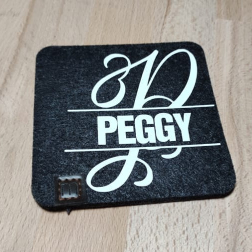 Monogramm "P" Plotterdatei von easy-sticks, individuelles schwarzes Filzuntersetzer mit dem Namen Peggy in eleganter Schrift.