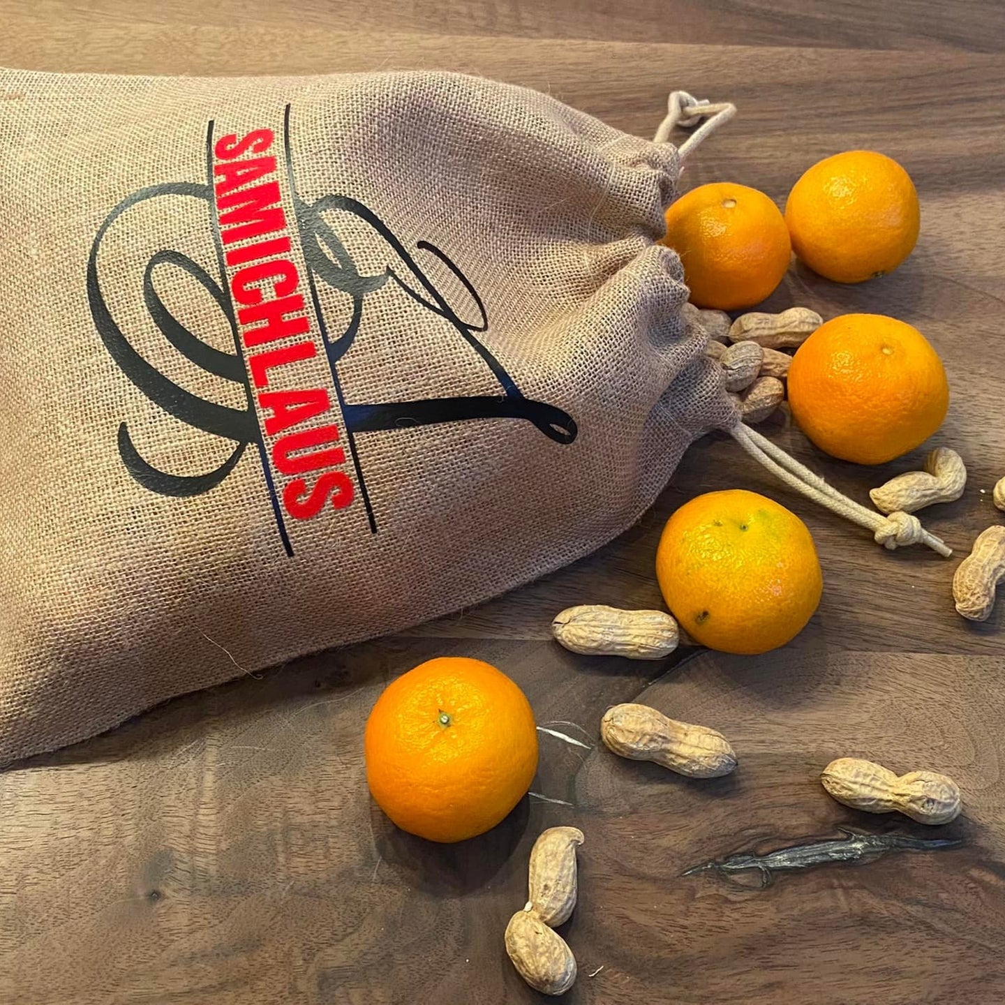 Sack mit Monogramm 'S' von easy-sticks, dekoriert mit Mandarinen und Erdnüssen, ideal für kreative Geschenkideen.