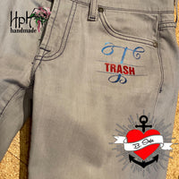 Stylische Jeans mit farbenfrohem Monogramm 'T' und dem Wort 'TRASH', kreiert von B.Style für kreative und persönliche Gestaltung.