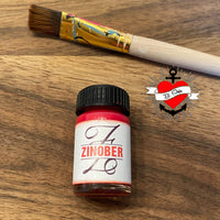 Monogram 'Z' Plotterdatei von easy-sticks: Farbtöpfchen in kräftigem Zinnoberrot neben einem Pinsel, ideal für kreative Bastelprojekte.