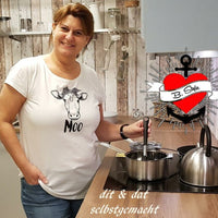 Frau in der Küche, die ein T-Shirt mit einem Kuh-Design und dem Schriftzug 'MOO' trägt, perfekt für DIY-Liebhaber, hergestellt von easy-sticks.