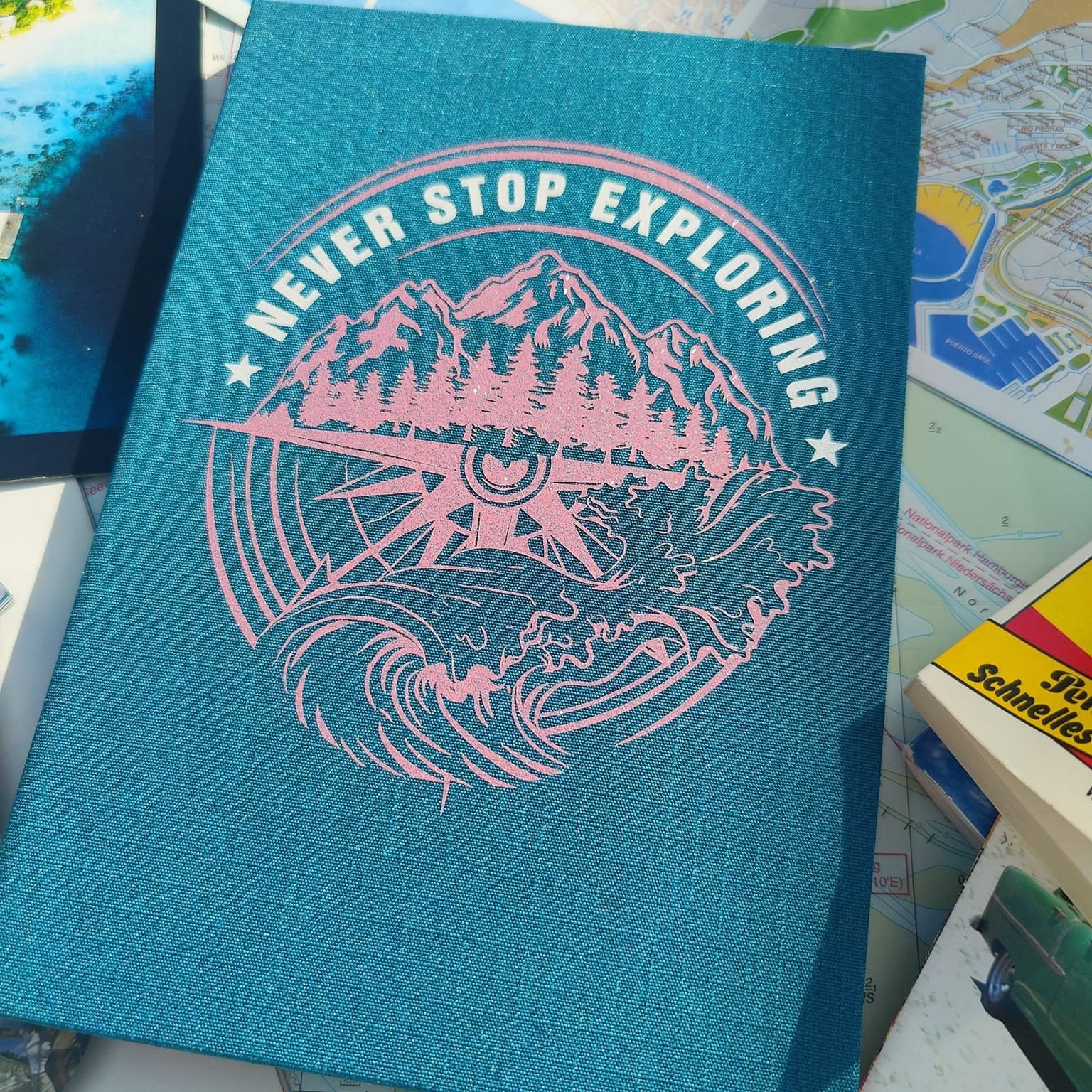 Notizbuch in Türkis mit rosa Aufdruck "NEVER STOP EXPLORING" und Naturdesign, angefertigt aus der Plotterdatei von easy-sticks.