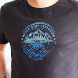 Schwarzes T-Shirt mit dem Aufdruck "NEVER STOP EXPLORING" in Blau- und Grüntönen, ideal für kreative Arbeiten mit der Plotterdatei von easy-sticks.