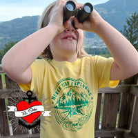 Kind im gelben T-Shirt mit dem Aufdruck "NEVER STOP EXPLORING" und Fernglas, inspiriert von der Plotterdatei von easy-sticks.