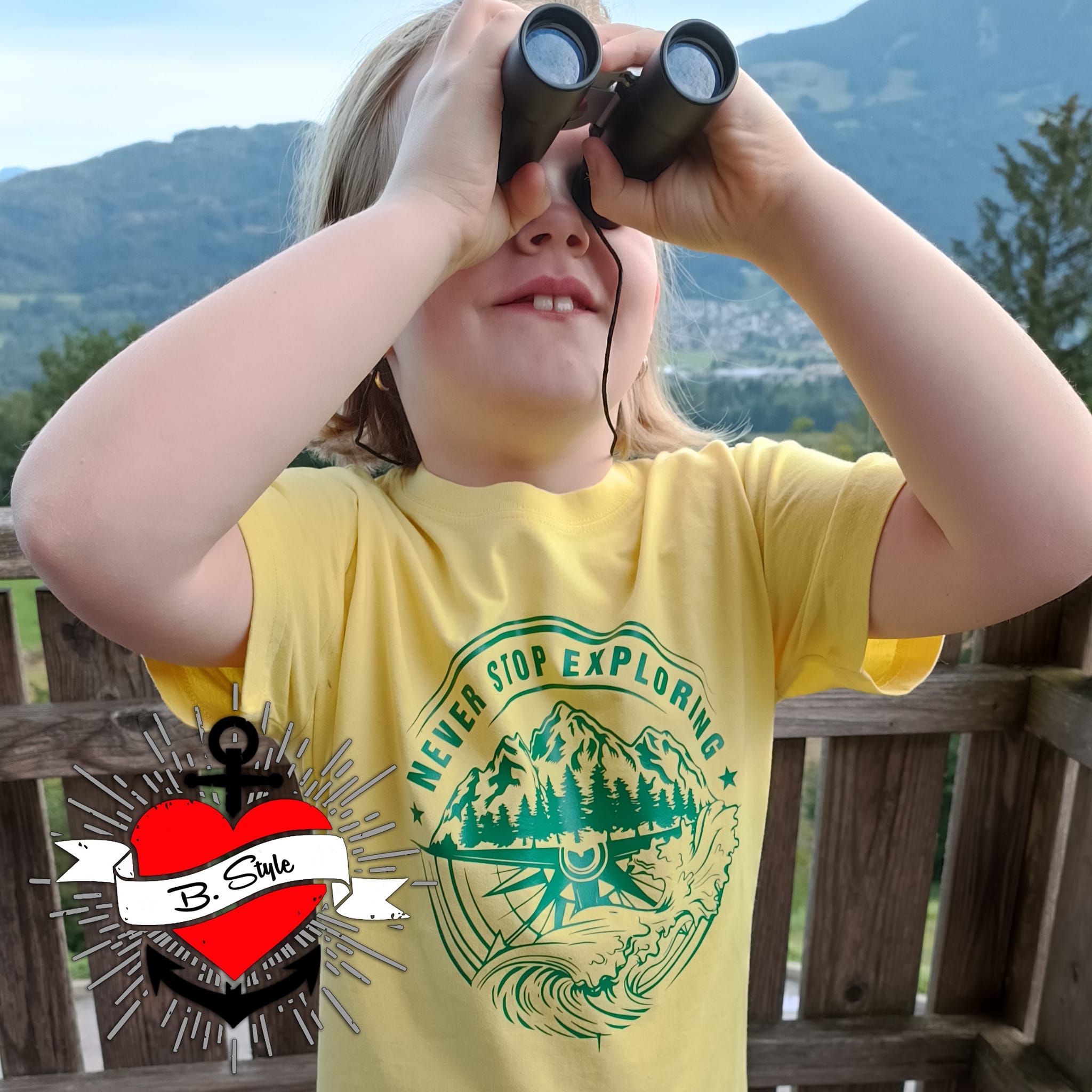 Kind im gelben T-Shirt mit dem Aufdruck "NEVER STOP EXPLORING" und Fernglas, inspiriert von der Plotterdatei von easy-sticks.