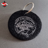 Nahaufnahme eines Anhängers aus Filz mit dem Motiv "NEVER STOP EXPLORING" von easy-sticks, erstellt aus der einzigartigen Plotterdatei, perfekt für kreative DIY-Projekte.