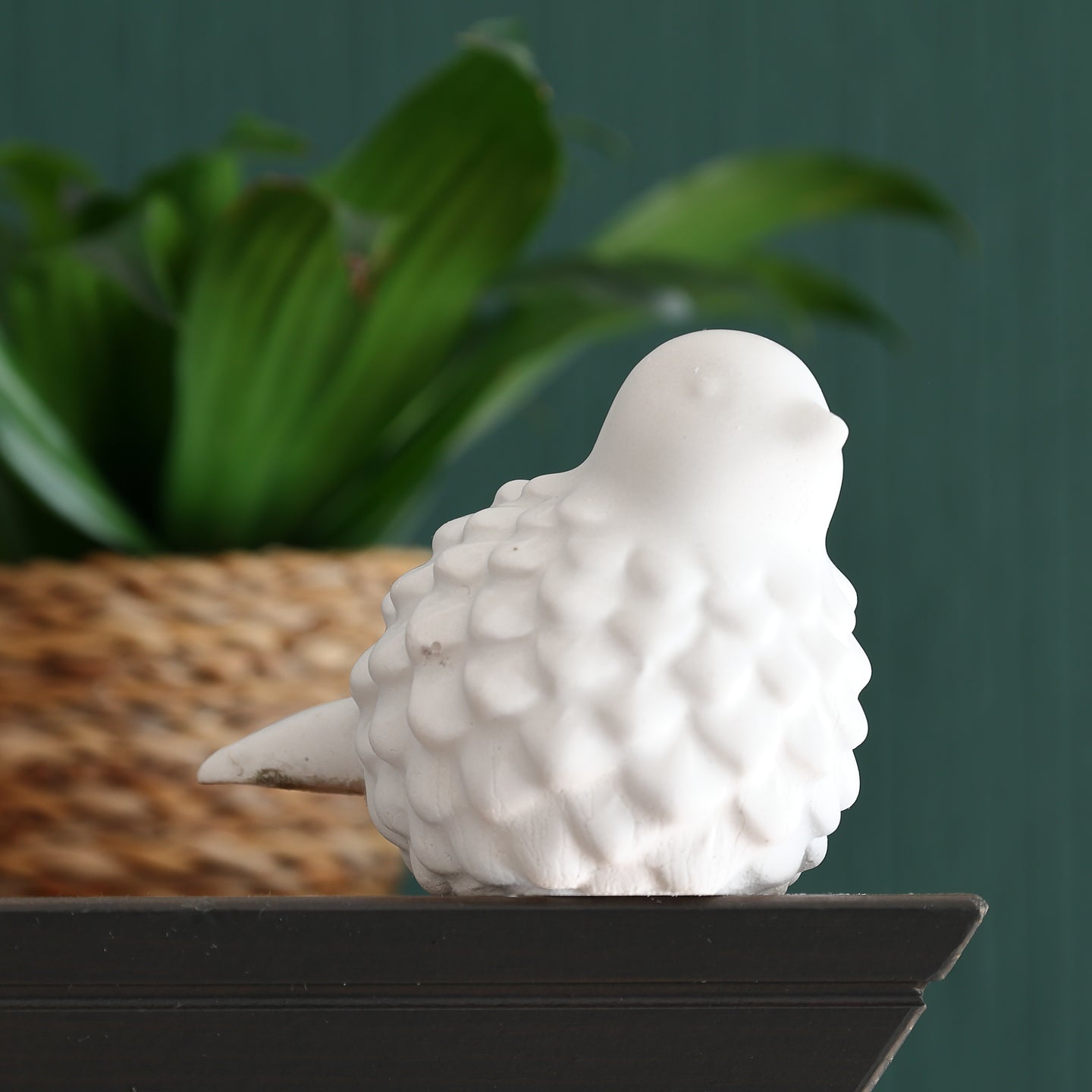 Silikonform - Vogel von Easy-Sticks, eine detailreiche, weiße Vogelskulptur auf einem Regal, umgeben von grünen Pflanzen im Hintergrund.