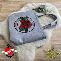 Stofftasche mit dem Aufdruck "No Regrets Only Memories" von easy-sticks, verziert mit einer roten Rose und grünen Blättern, vorsichtig drapiert auf einem weichen Hintergrund.