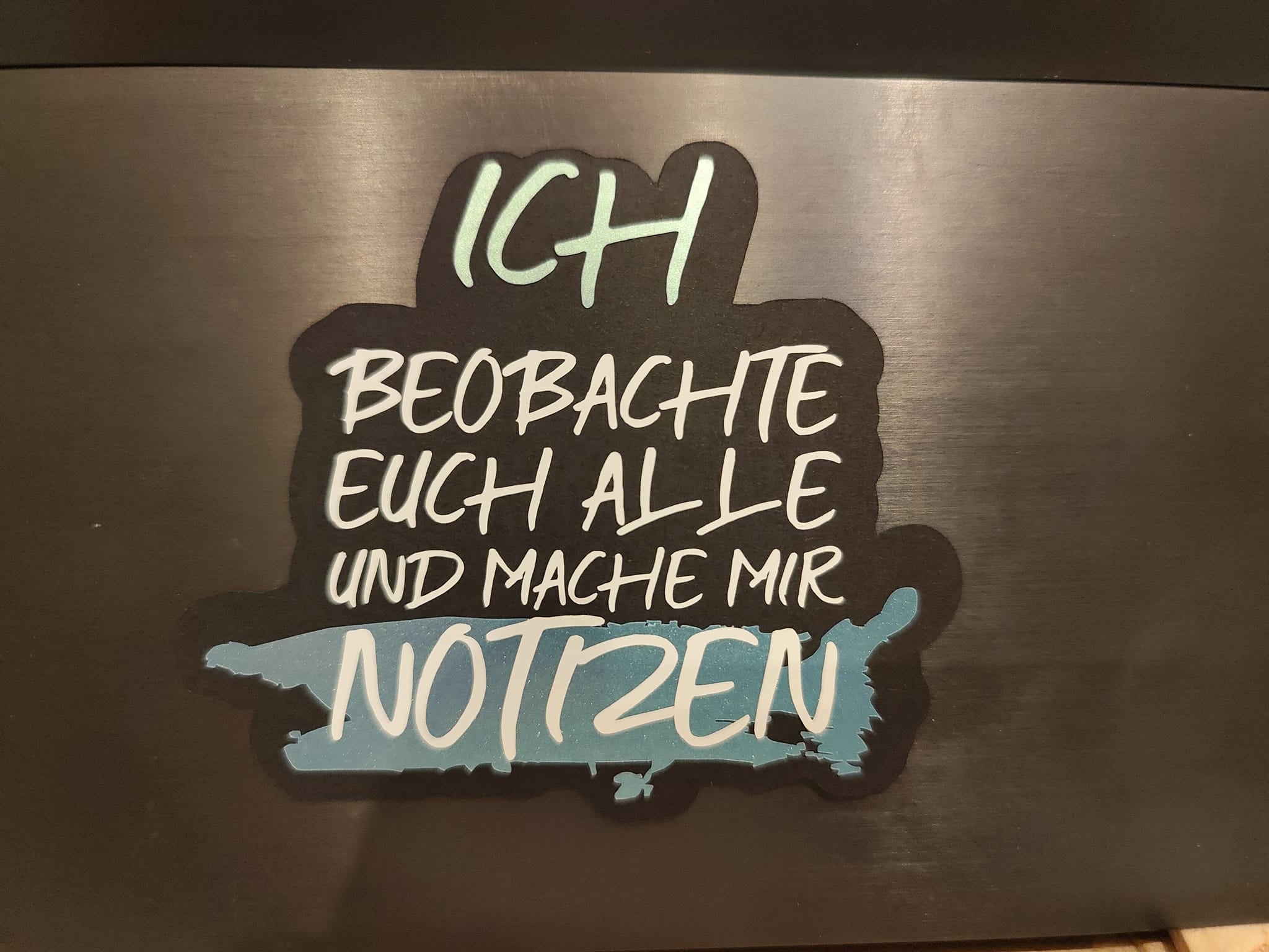Bunte Aufkleber-Variante der Plotterdatei von easy-sticks mit dem Titel "ICH BEOBACHTE EUCH ALLE UND MACHE MIR NOTZEN". Ideal für kreative Bastelarbeiten und individuelle Designs.