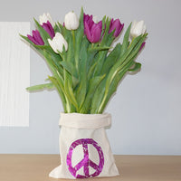 Eine Stofftasche mit einem lila Peace-Symbol, die Blumen präsentiert, entworfen mit der "PEACE" Grunge Schriftart Plotterdatei von easy-sticks. Ideal für kreative DIY-Gestaltungen! Plotterdatei.