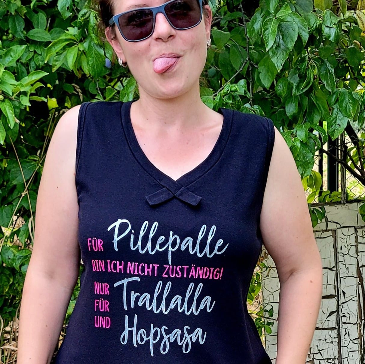 Eine Person mit Sonnenbrille zeigt den plakativen Schriftzug "Für Pillepalle bin ich nicht zuständig! Nur für Trallalla und für Hopsasa" auf ihrem schwarzen Shirt, entworfen von easy-sticks in dieser Plotterdatei.