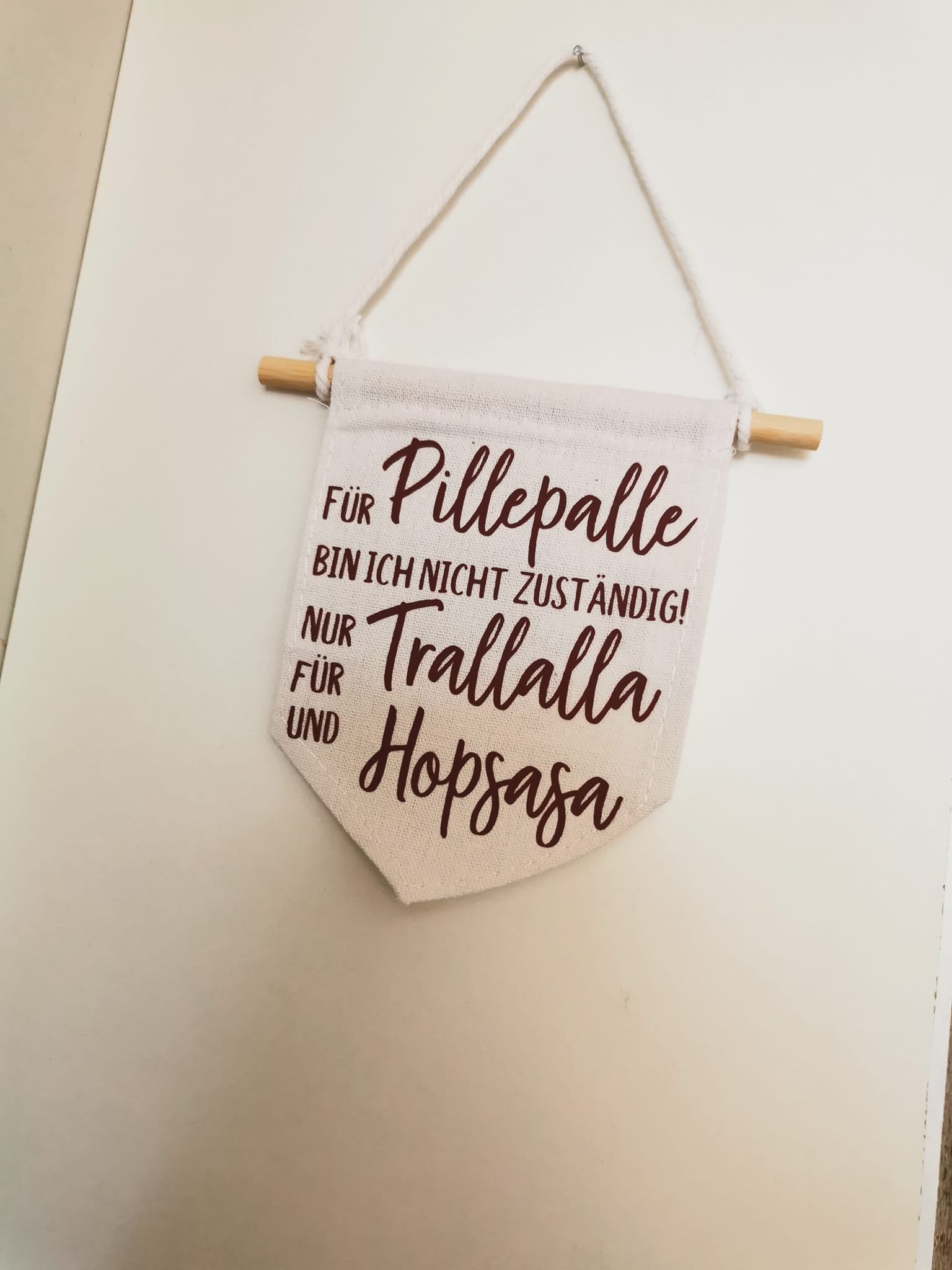 Ein dekoratives Wandbanner aus Stoff präsentiert den Spruch "Für Pillepalle bin ich nicht zuständig! Nur für Trallalla und für Hopsasa" in elegantem Design, basierend auf der Plotterdatei von easy-sticks.