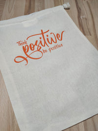 Zugehöriger Stoffbeutel mit "Think positiver be positive" in leuchtendem Orange, gestaltet von easy-sticks. Praktisch für den Alltag und trägt positive Energie.
