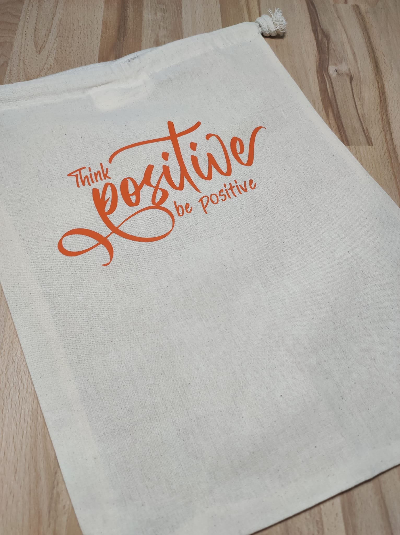 Zugehöriger Stoffbeutel mit "Think positiver be positive" in leuchtendem Orange, gestaltet von easy-sticks. Praktisch für den Alltag und trägt positive Energie.