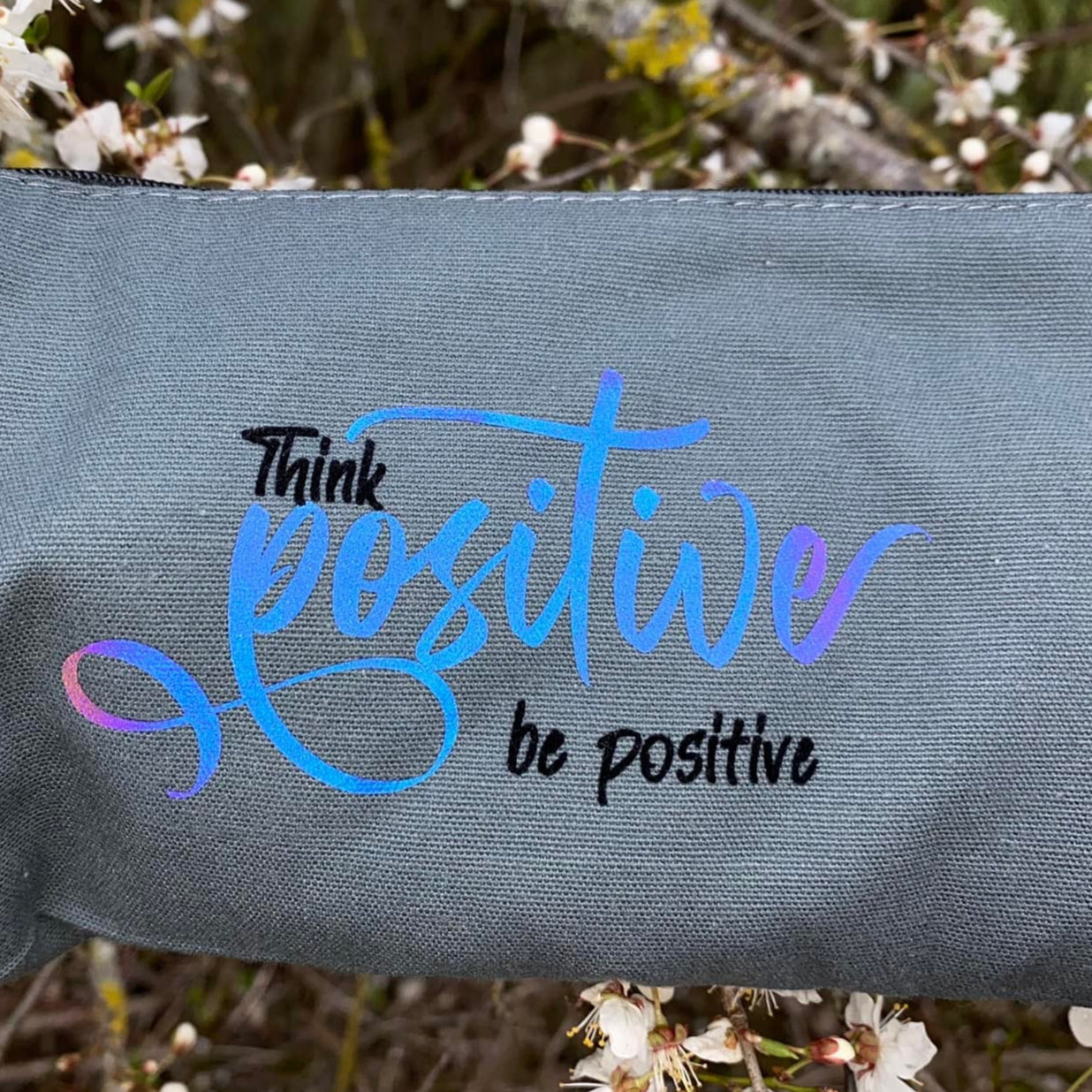 Kleines Täschchen mit der Aufschrift "Think positiver be positive" in bunten Farben, designt von easy-sticks. Perfekt für kreative Projekte und persönlichen Stil.