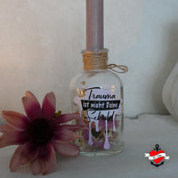 Eine stilvolle Glasflasche mit dem Schriftzug 'Trauma ist nicht deine Schuld', designt mit der Psyche Plotterdatei von easy-sticks.