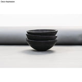 Raysin Gießpulver - Schwarze Schalen aus Raysin 250 Black dekorativ gestapelt auf neutralem Hintergrund.