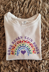 T-Shirt mit dem kreativen Spruch "Regenbogen - Ohne Regen kein Bogen" von easy-sticks, ideal für persönliche Modekreationen.