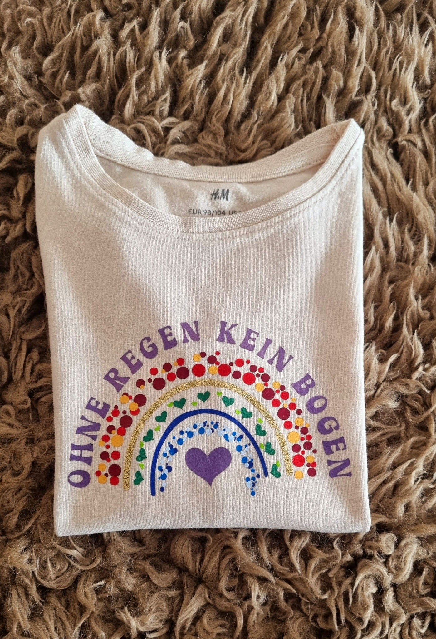T-Shirt mit dem kreativen Spruch "Regenbogen - Ohne Regen kein Bogen" von easy-sticks, ideal für persönliche Modekreationen.