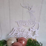 Kreative Rentier Plotter Datei von easy-sticks, filigranes, weißes Rentierdesign auf einer Holzplatte mit Weihnachtskugeln, ideal für DIY-Projekte.