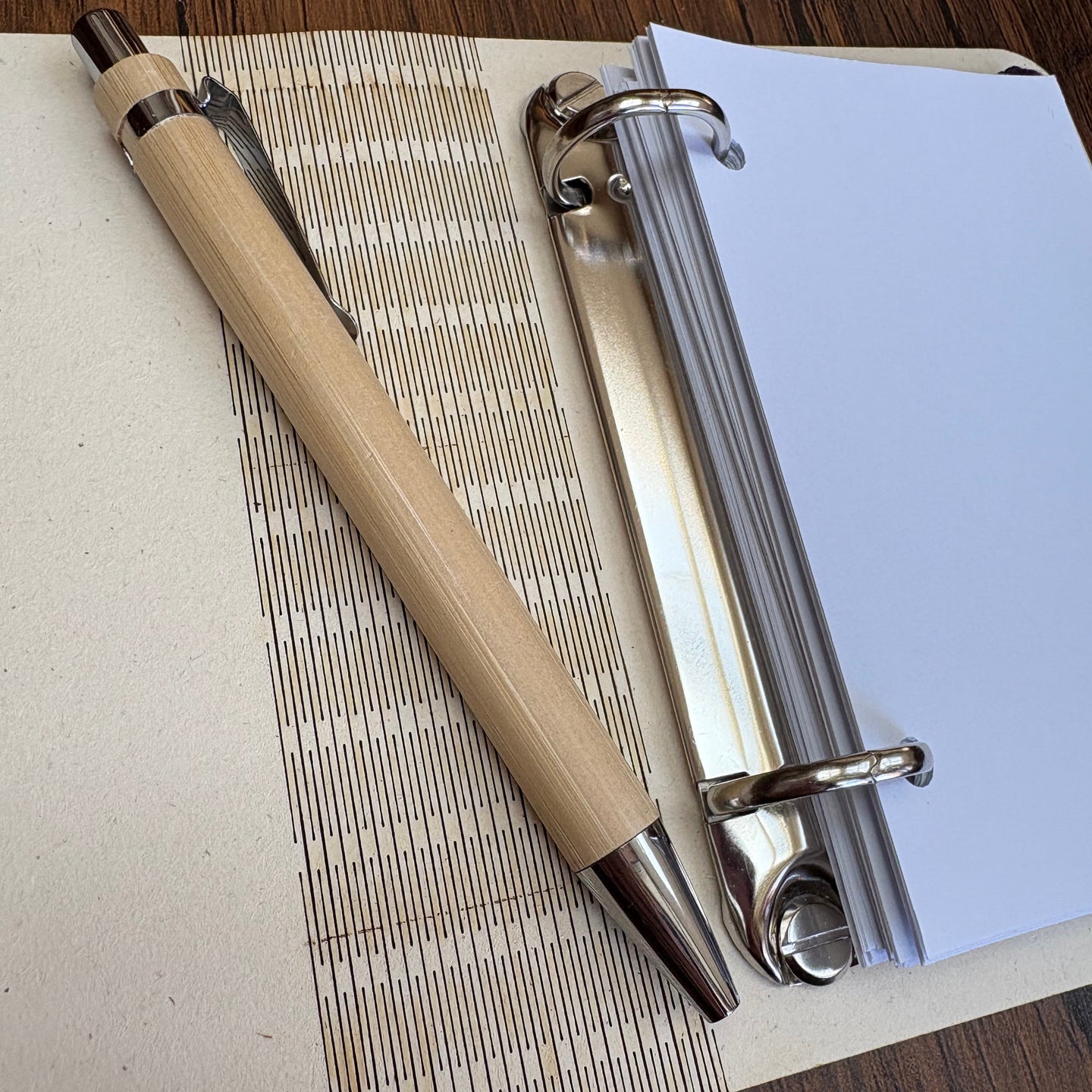 Bamboo-Stift auf einem weißen Ringbuch mit blanko Seiten, ideal für kreative Projekte mit der Laserdatei von Easy-Sticks.