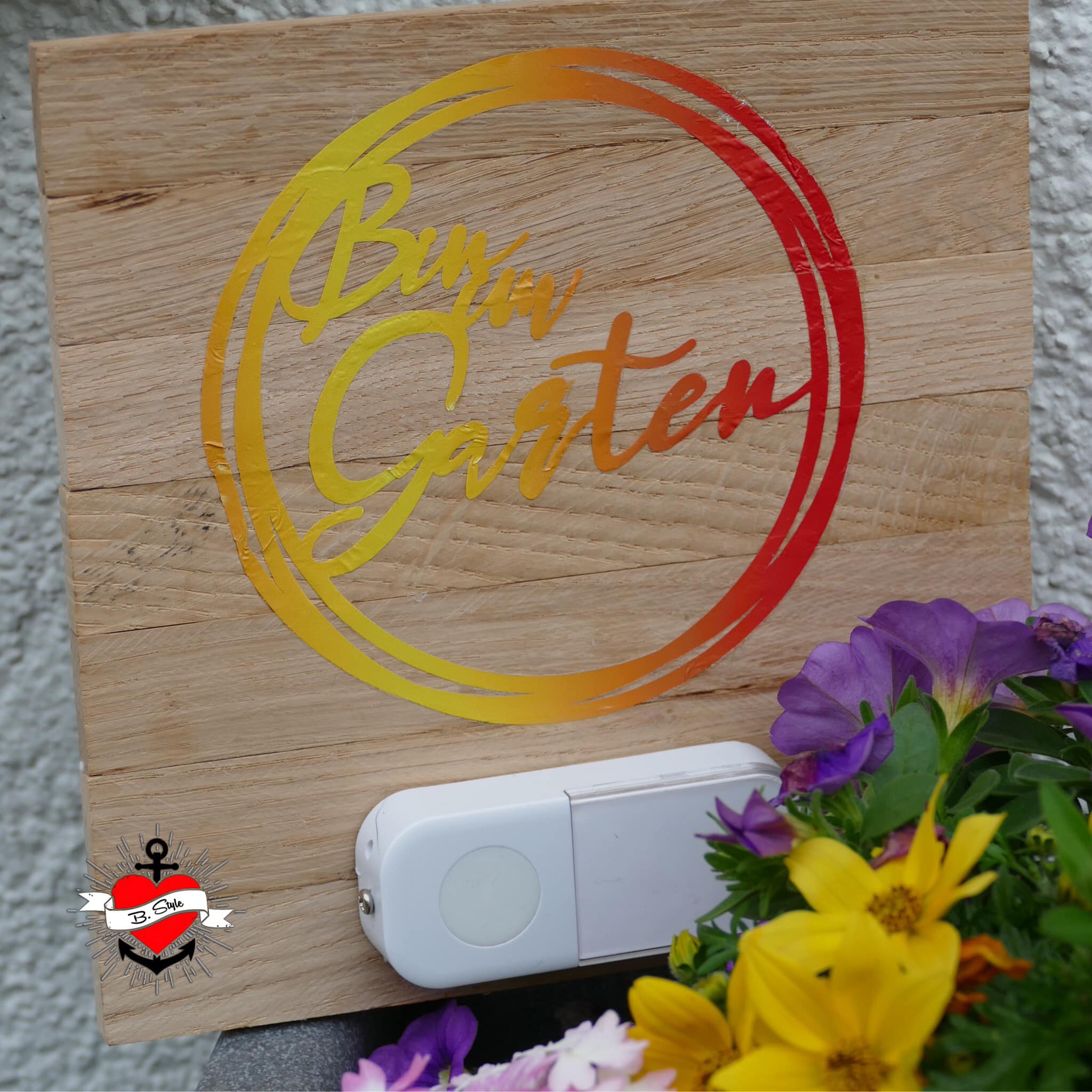 Holzschild mit dem Schriftzug 'Bin im Garten' in leuchtenden Farben, kombiniert mit Blumenarrangement, von easy-sticks, für kreative Projekte.