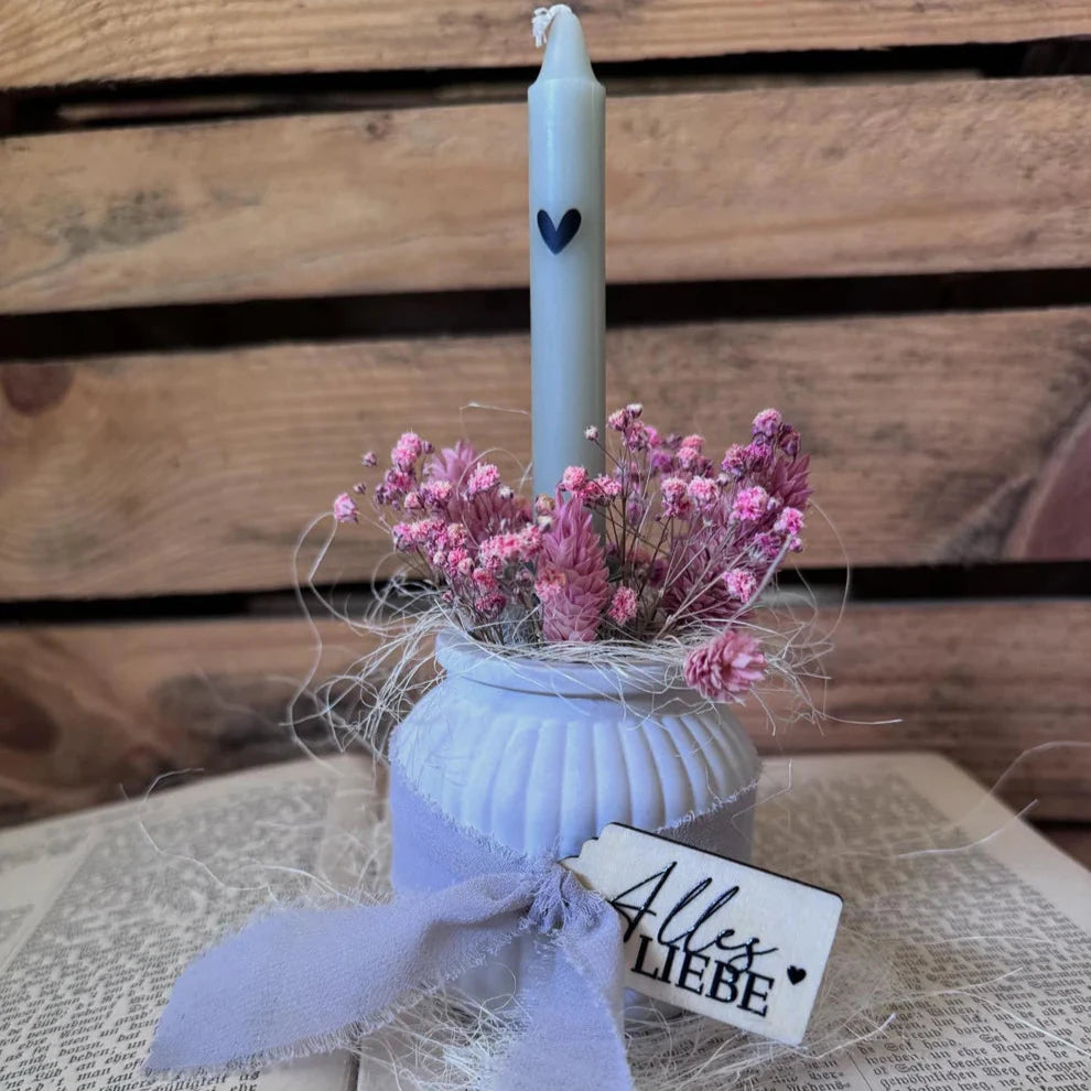 Schöne Dekoration mit einer Kerze in einem stilvollen Gefäß, umgeben von Trockenblumen und einem Anhänger mit dem Schriftzug 'Alles Liebe'. Perfekt als Geschenk oder für den eigenen Wohnbereich, gestaltet mit den RUB ON UV Stickern von easy-sticks.