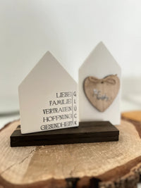 Zwei dekorative Häuschen mit Rub On UV Stickern von easy-sticks, die positive Botschaften wie 'Liebe' und 'Familie' in stilvollem Design präsentieren.