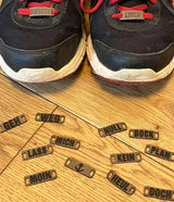 Schuhe mit individuell gestalteten Schnürsenkel-Schildern von easy-sticks: Die Armband- und Schnürsenkel-Schilder mit Wörtern machen jeden Look einzigartig.