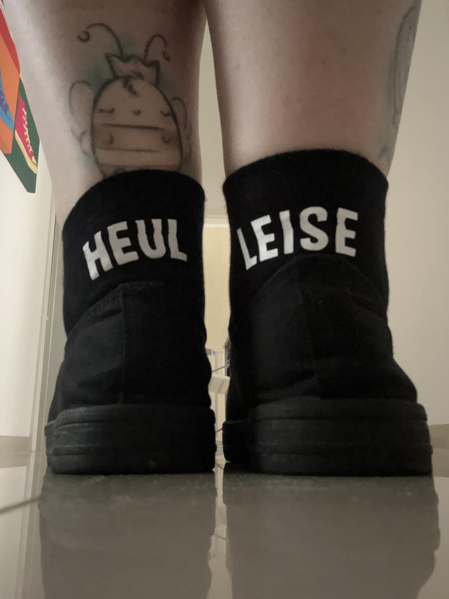 Schwarze Sneakers mit den Aufschriften 'HEUL' und 'LEISE', kombiniert mit einem verspielt gezeichneten Tattoo. Ein cooles Beispiel für die Kreativität aus der Plotter und Laser Datei von easy-sticks.