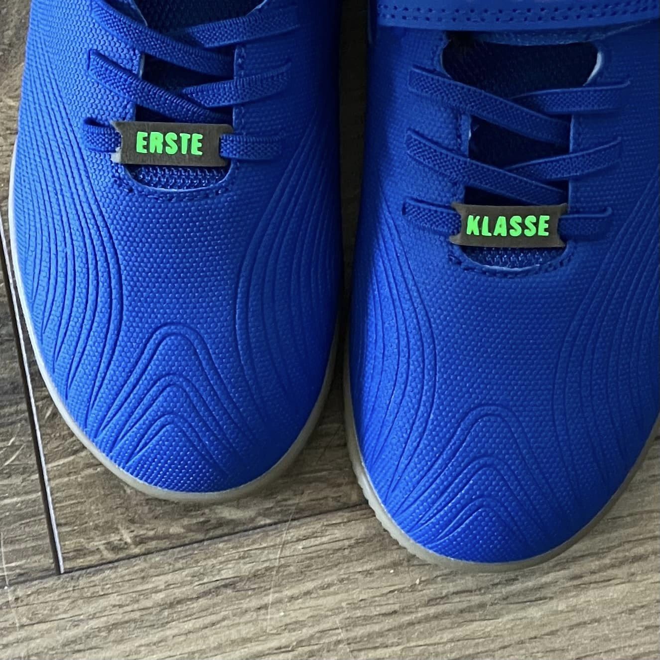 Blaue Schuhe mit bequemen Schnürsenkel-Schildern von easy-sticks: Die Armband- und Schnürsenkel-Schilder mit Wörtern bringen Persönlichkeit in dein Schuhwerk.