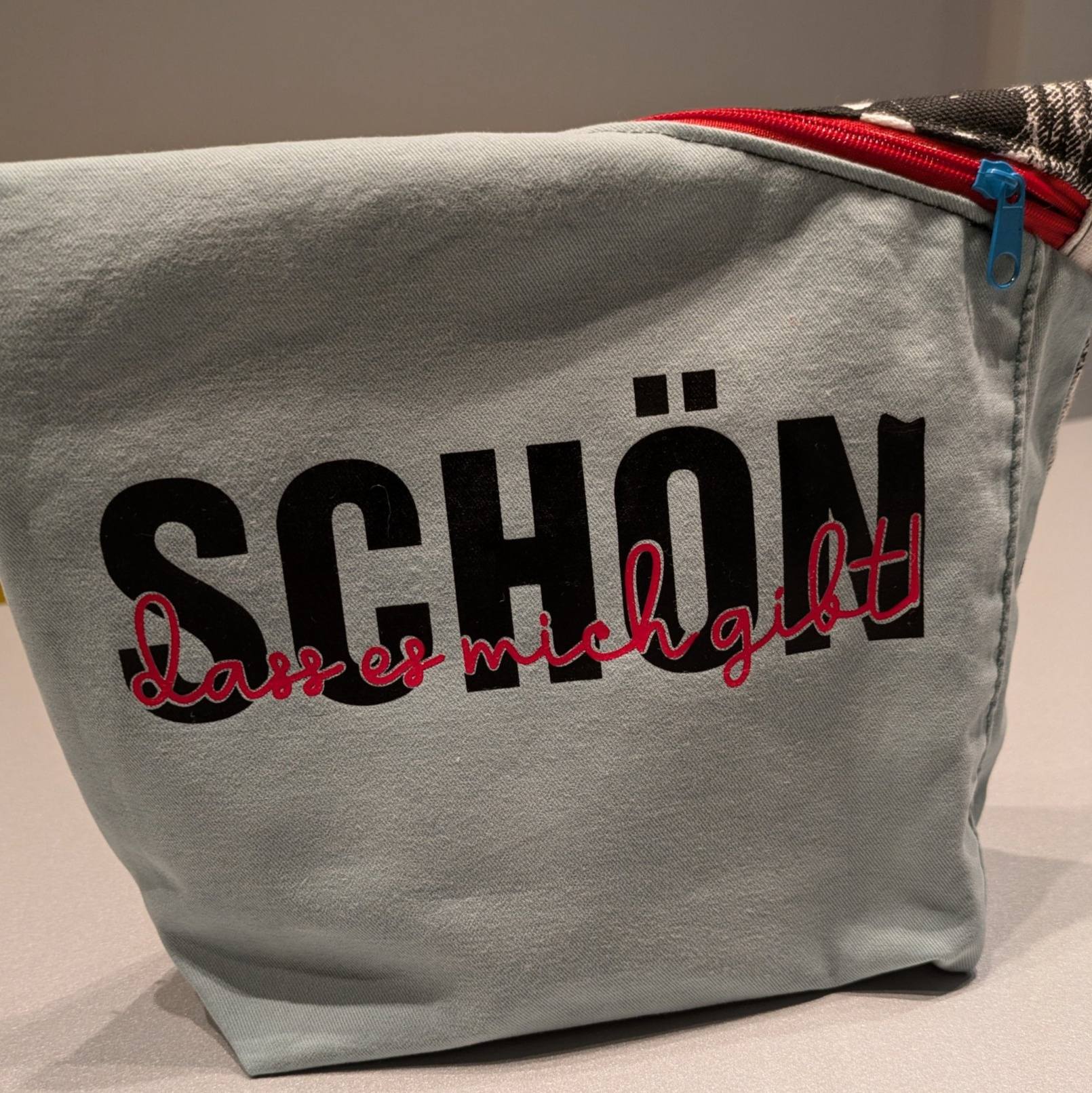 Bunte Kosmetiktasche mit dem Aufdruck 'SCHÖN, dass es mich gibt' von easy-sticks, inspiriert von der Plotterdatei, ideal für kreative Projekte.