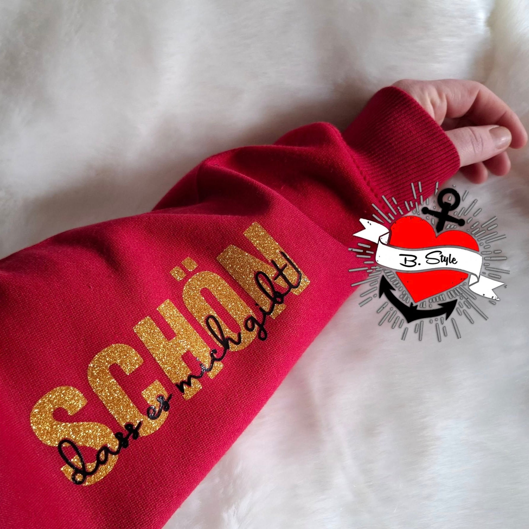 Ein rotes Sweatshirt mit goldenem Aufdruck des Designs "Schön, dass es mich gibt". Diese Plotterdatei von easy-sticks eignet sich perfekt für individuelle Bekleidungsprojekte.