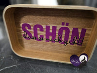 Ein Holztablett mit dem Satz "Schön, dass es mich gibt" in lila Schrift. Diese Plotterdatei von easy-sticks bietet kreativen Spielraum für verschiedene DIY-Projekte.
