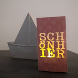 Lichtdurchlässige Deko mit der "SCHÖN HIER" Plotterdatei von easy-sticks, schematisches Design auf einer Karte, perfekt für kreative Projekte.
