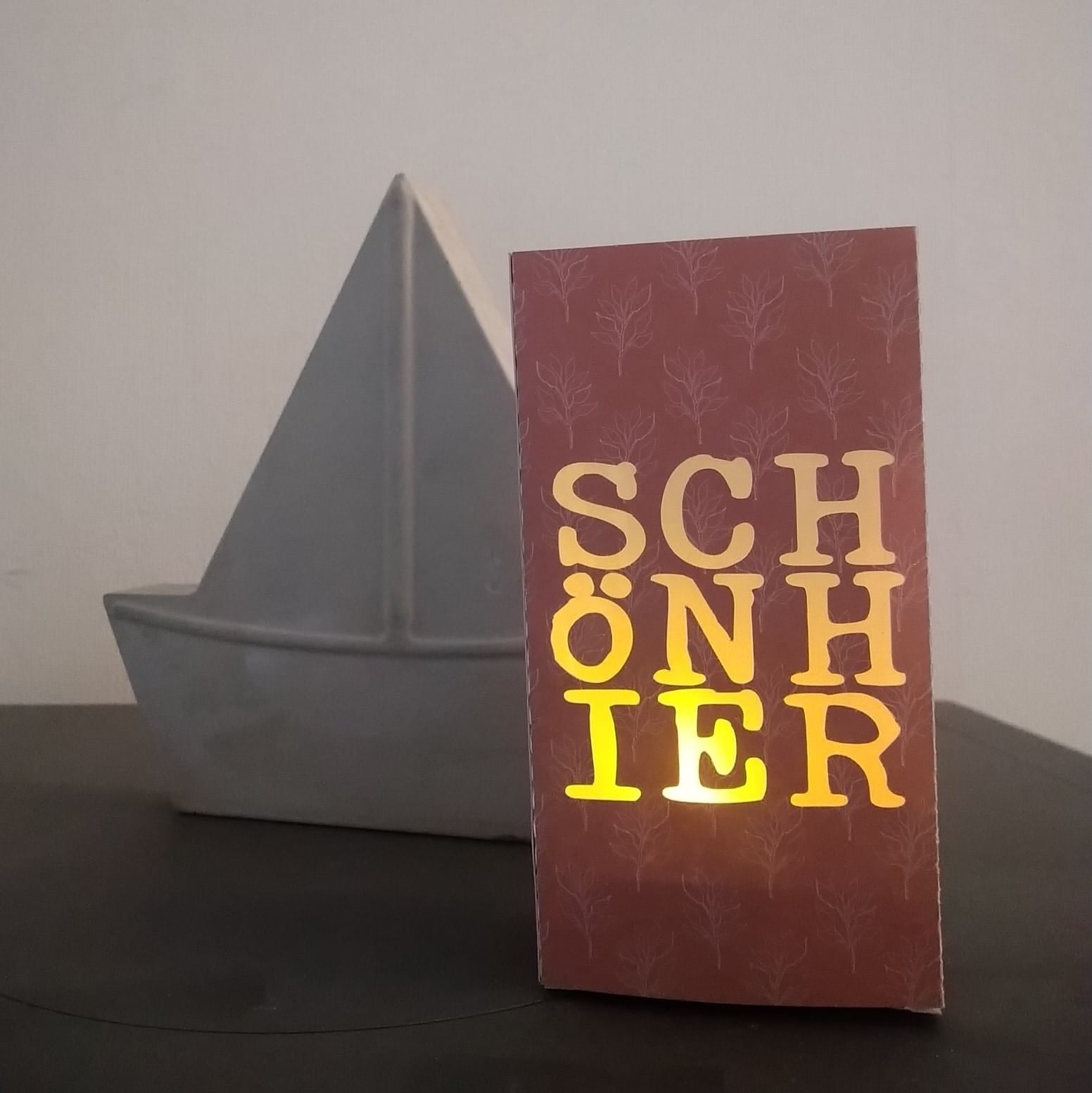 Lichtdurchlässige Deko mit der "SCHÖN HIER" Plotterdatei von easy-sticks, schematisches Design auf einer Karte, perfekt für kreative Projekte.