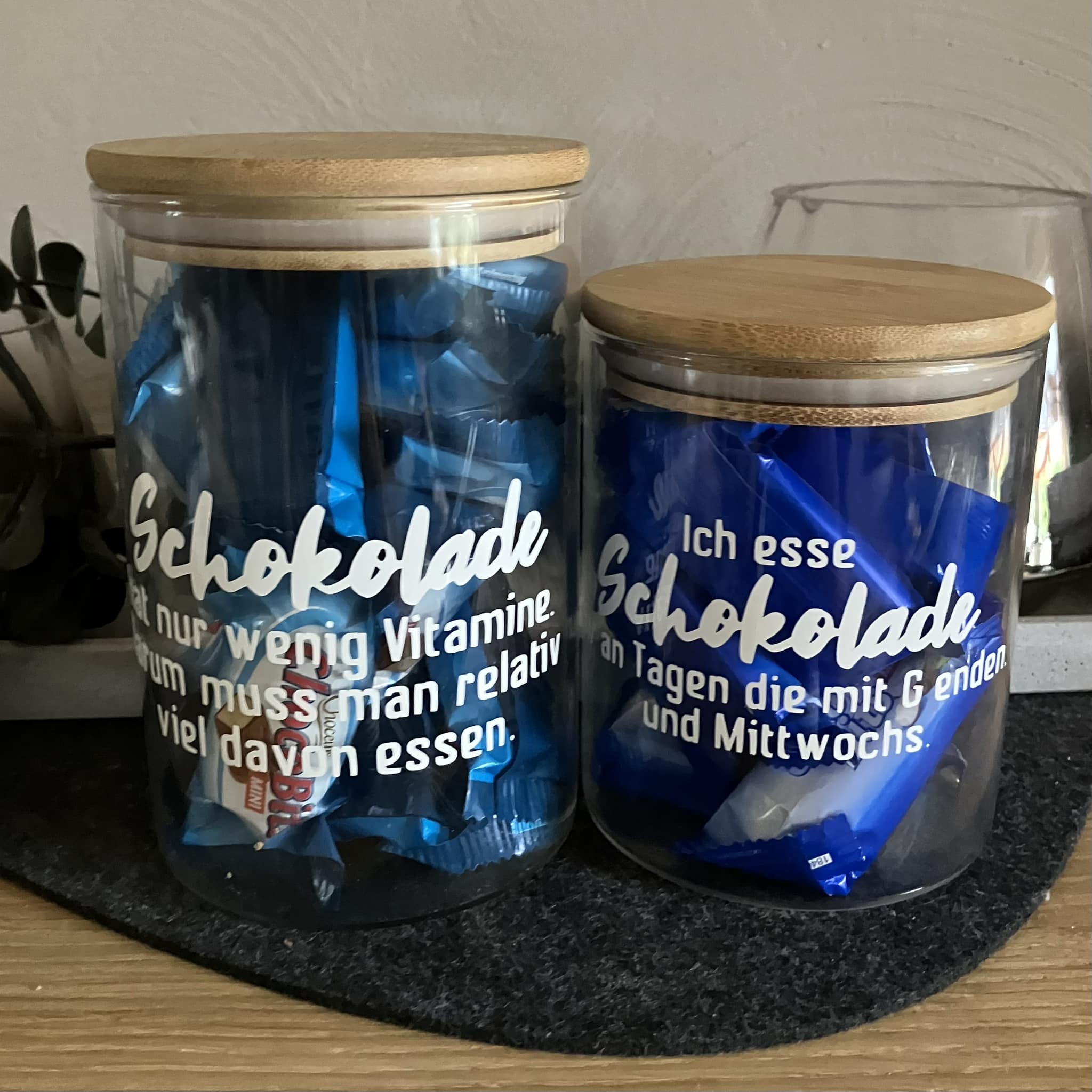 Schokolade Sprüche Plotterdatei von easy-sticks, zwei Glasbehälter mit Schokoladenverpackungen, verziert mit witzigen Schokoladensprüchen.