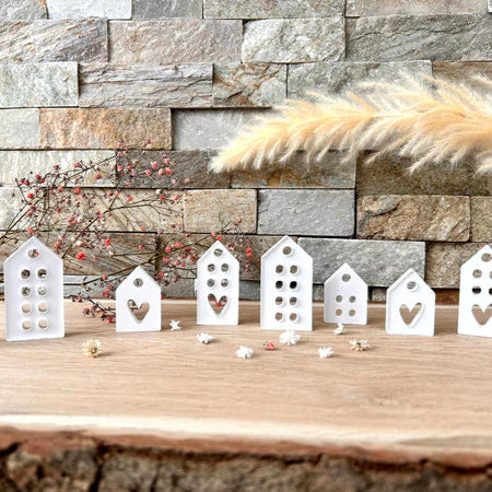 Silikonform - Minihäuser zum Aufhängen von Easy-Sticks, stilvolle Arrangement mit verschiedenen Hausdesigns auf einem Holztisch.