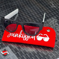 Schwarze Sonnenbrille auf rotem Untergrund mit dem Schriftzug "Sunkissed". Ideal für den Sommerlook. Inspirierende Designs mit der "Sommer und Urlaub Sprüche" Plotterdatei von easy-sticks.