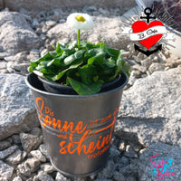 Blumtopf mit dem Aufdruck "Die Sonne ist auch alleine und scheint trotzdem", verziert mit einer schönen Blume, entworfen von easy-sticks für kreative Bastelideen.