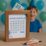 Wunscherfüller PDF für Spardose in Blau von easy-sticks, präsentiert mit einem Holzrahmen, Geldscheinen und einem lächelnden Jungen im Hintergrund. Perfekte Geldgeschenk Idee für Jungen.