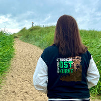 Frau mit Stadionzeit Jacke von easy-sticks auf einem Sandweg, ideal für Fußballfans, zeigt Stolz und Leidenschaft für die Stadionzeit.