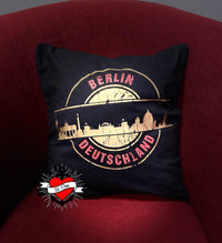 Kissen mit schwarzem Bezug und goldener Grafik der Berliner Skyline. Inklusive dem Schriftzug "DEUTSCHLAND". Ideal für individuelle Gestaltung mit der Stempel Skyline Berlin Plotterdatei von easy-sticks.